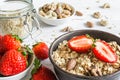 Bowl of oat muesli with strawberry, granola and nuts on rustic w