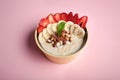 Bowl of oatmeal with a banana, strawberries, almonds, hazelnuts and butter on a pink background. Hot and a healthy dish for Breakf Royalty Free Stock Photo