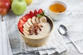 Bowl of oatmeal with a banana, strawberries, almonds, hazelnuts and butter on a rustic table. Hot and a healthy dish for Breakfast Royalty Free Stock Photo