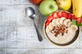 Bowl of oatmeal with a banana, strawberries, almonds, hazelnuts and butter on a rustic table. Hot and a healthy dish for Breakfast Royalty Free Stock Photo