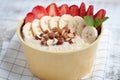 Bowl of oatmeal with a banana, strawberries, almonds, hazelnuts and butter on a rustic table. Hot and a healthy dish for Breakfast Royalty Free Stock Photo