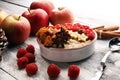 Bowl of oatmeal porridge with banana, apples,raspberries coconut and caramel sauce on rustic table, hot and healthy food for Royalty Free Stock Photo