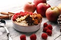 Bowl of oatmeal porridge with banana, apples,raspberries coconut and caramel sauce on rustic table, hot and healthy food for Royalty Free Stock Photo