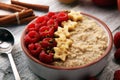 Bowl of oatmeal porridge with banana, raspberries coconut and caramel sauce on rustic table, hot and healthy food for Breakfast