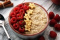 Bowl of oatmeal porridge with banana, raspberries coconut and caramel sauce on rustic table, hot and healthy food for Breakfast Royalty Free Stock Photo