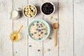 Bowl of oatmeal porridge with blueberry on vintage table with honey and milk. Top view in flat lay style. Healthy Royalty Free Stock Photo