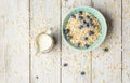 Bowl of oatmeal porridge with milk and blueberry on vintage table top view in flat lay style. Hot breakfast and homemade Royalty Free Stock Photo