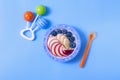 Bowl with oatmeal , raw , for a child, with apple slices ,banana, and blueberies, top view on a blue background Royalty Free Stock Photo