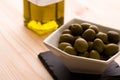 A bowl of olives with the olive oil bottle in the background Royalty Free Stock Photo