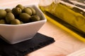 A bowl of olives with the olive oil bottle in the background Royalty Free Stock Photo