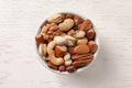 Bowl with organic mixed nuts on white wooden background Royalty Free Stock Photo