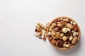 Bowl with organic mixed nuts on white wooden background, top view. Royalty Free Stock Photo