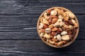 Bowl with organic mixed nuts on wooden background, top view. Royalty Free Stock Photo