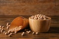 Bowl and paper cone with dry chickpeas on wooden table Royalty Free Stock Photo