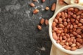 Bowl with peanuts on grey textured background