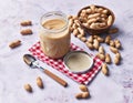 Bowl of peanuts with shell and peanut butter cream on a marble surface Royalty Free Stock Photo