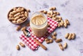 Bowl of peanuts with shell and peanut butter cream on a marble surface Royalty Free Stock Photo