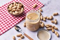 Bowl of peanuts with shell and peanut butter cream on a marble surface Royalty Free Stock Photo