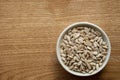 Bowl of peeled raw sunflower seeds on a wooden background. Copy space. Top view Royalty Free Stock Photo