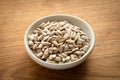 Bowl of peeled raw sunflower seeds on a wooden background. Low angle view Royalty Free Stock Photo