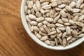 Bowl of peeled raw sunflower seeds on a wooden background. Top view Royalty Free Stock Photo