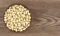 Bowl with pine nuts on a wooden table