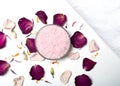 bowl of pink coarse grained salt surrounded by red rose petals on white table. Royalty Free Stock Photo