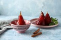 Bowl and plate with delicious poached pears in red wine on color table Royalty Free Stock Photo