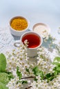 A bowl of pollen, aromatic herbal tea and white honey. Still life in a rustic style with a branch and flowers of a bird