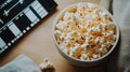 A bowl of popcorn beside a film clapperboard on a wooden table Royalty Free Stock Photo