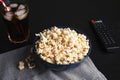 Bowl with popcorn, glass of iced cola