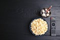 Bowl with popcorn, glass of iced cola and TV remote