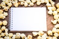 A bowl of popcorn and notebook on a wooden table Royalty Free Stock Photo