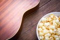 A bowl of popcorn and Ukulele on a wooden table Royalty Free Stock Photo