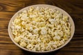 Bowl with popcorn on wooden table Royalty Free Stock Photo
