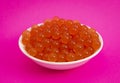 Bowl of Popping Boba Pearls on a Bright Pink Background