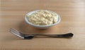 Bowl of potato and eggs salad on a wood table side view