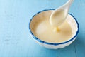 Bowl with pouring condensed milk or evaporated milk. Royalty Free Stock Photo