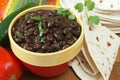 Bowl of prepared black beans with tortillas