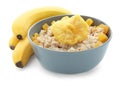 Bowl with prepared oatmeal, dried pineapple and bananas on white background Royalty Free Stock Photo