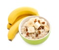 Bowl with prepared oatmeal, raisins and bananas on white background