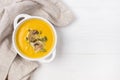 Bowl of Pumpkin and Mushrooms Soup with Cream and Pumpkin Seeds on Linen Napkin White Wooden Background Top View Copy Space Royalty Free Stock Photo