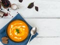 Bowl with pumpkin soup and pumpkin seeds. Old wooden white background. Top view, flat plan. Autumn Halloween Royalty Free Stock Photo