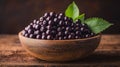 A bowl of purple berries with a leaf on top Royalty Free Stock Photo