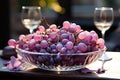 Bowl with purple grapes and two glasses sparkling wine on table. Royalty Free Stock Photo