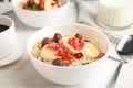 Bowl of quinoa porridge with hazelnuts, kiwi, banana and pomegranate seeds served for breakfast on white table Royalty Free Stock Photo