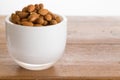 Bowl of raw almond nuts on wooden table Royalty Free Stock Photo