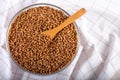 Bowl of raw buckwheat on wooden background. Buckwheat groats hulled seeds in bowl