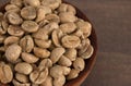 Bowl of Raw Green Coffee Beans on a Wooden Table Royalty Free Stock Photo