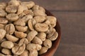 Bowl of Raw Green Coffee Beans on a Wooden Table Royalty Free Stock Photo